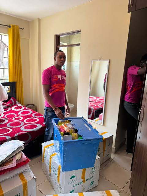 Busia Movers packer carefully loading a labelled crate in a bedroom