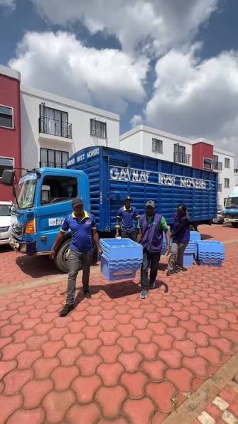 Movers carrying crates from truck at apartment complex
