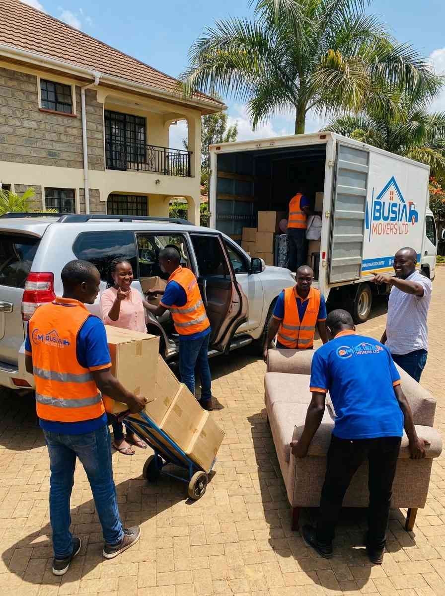 Busia Movers team in safety vests loading SUV for client